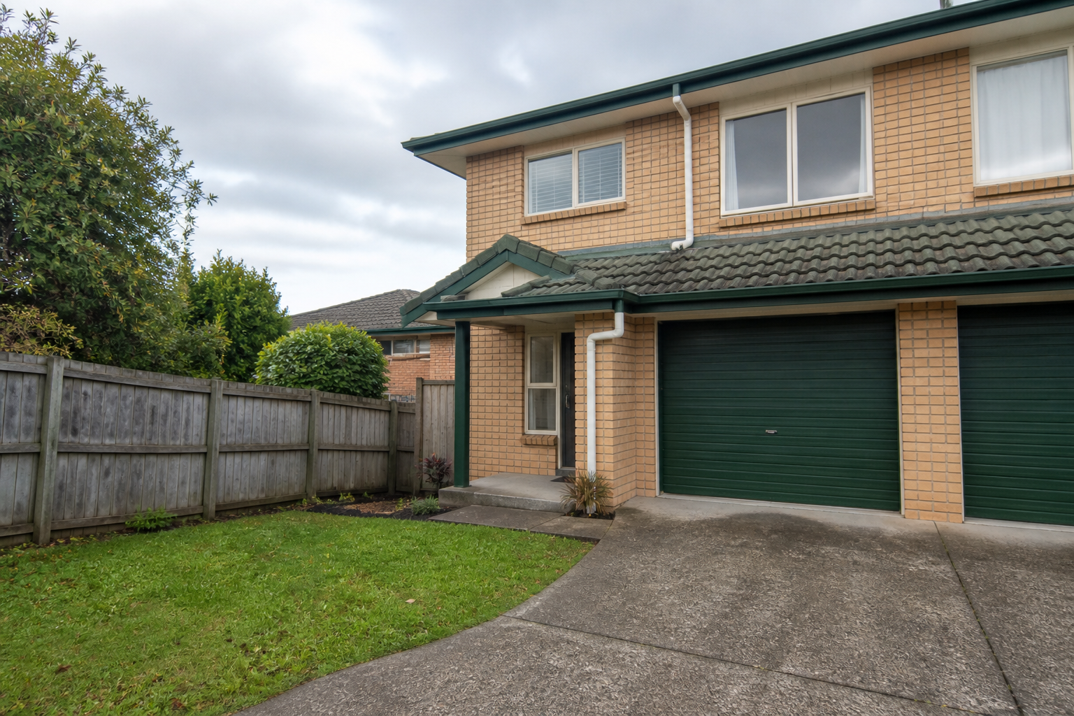 Auckland home exterior with driveway, lawn and fencing